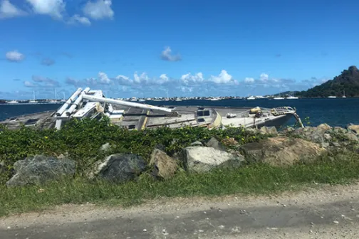 A capsized boat washed ashore after a Caribbean hurricane